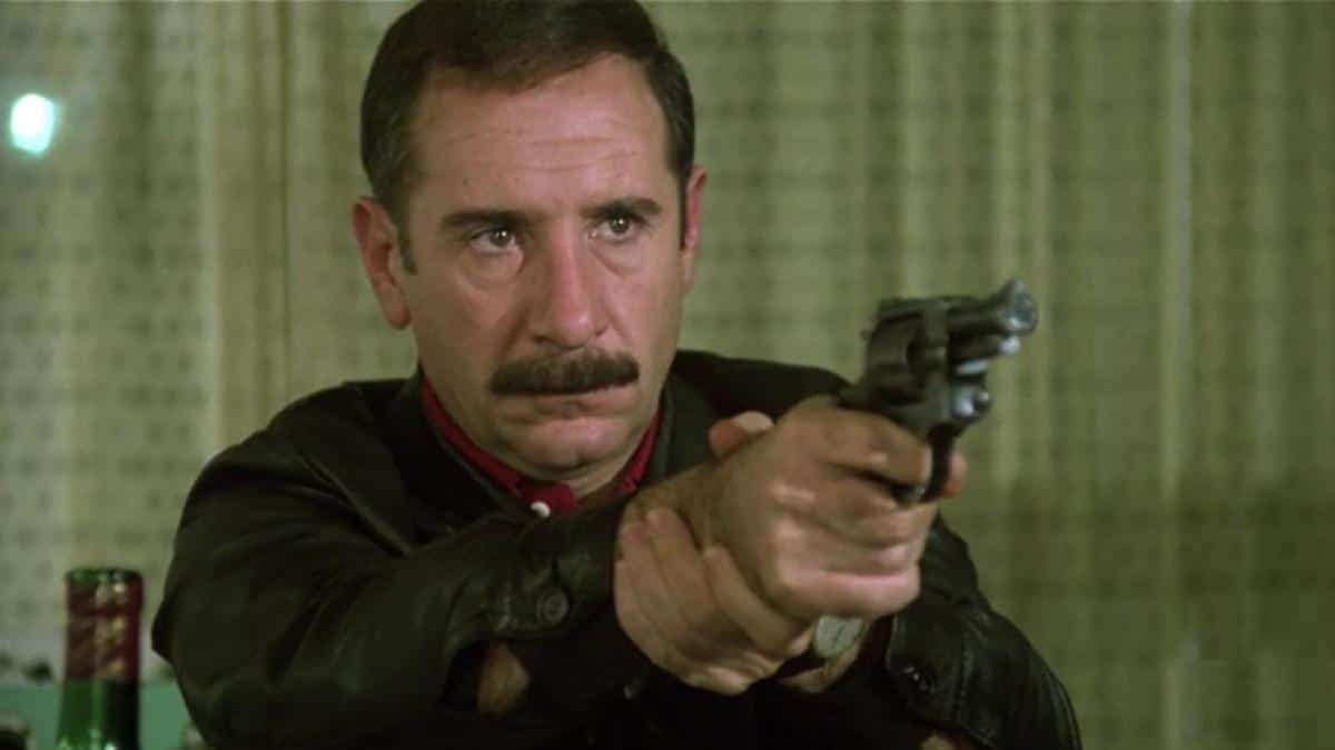 en la imagen el actor alfredo landa con bigote apuntando con un revolver a alguien en un fotograma de el crack