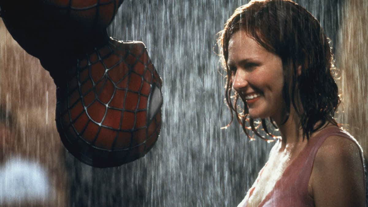 cara de mujer sonriendo con spiderman en la lluvia, escena de cine de superhéroes.