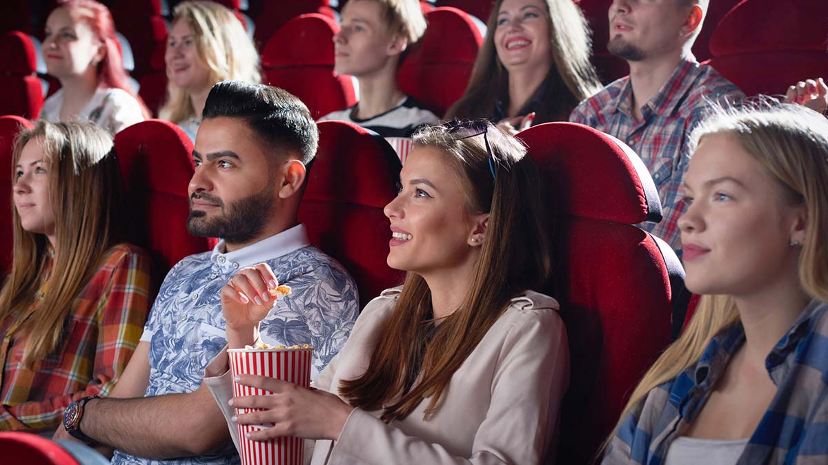 sala de cine casi vacía iluminada por el haz del proyector, simbolizando la caída de espectadores y la crisis de asistencia a los cines en 2025.
