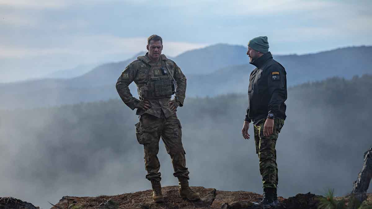 war machine. (l-r) alan ritchson as 81 and director patrick hughes on the set of war machine. cr. ben king/netflix &copy; 2026.